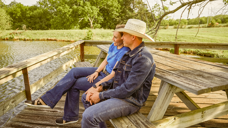 Cody and women sitting on picnic bench looking out over water